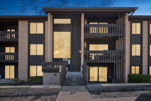 Front view of a multi-story building with balconies and large windows.