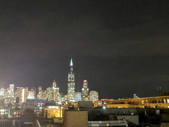 City skyline view at night with illuminated skyscrapers.