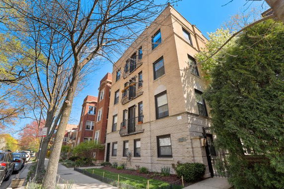 Front view of a multi-story brick apartment building.