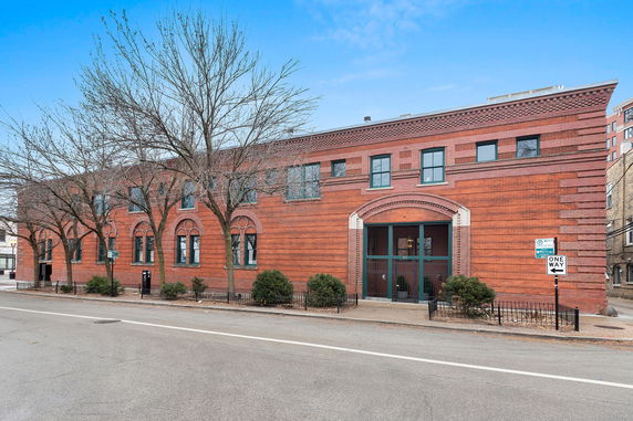 Front view of a brick two-story building with arched windows.