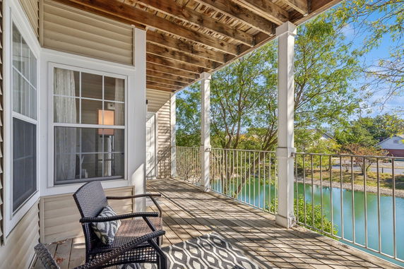 View from a balcony overlooking a pond and trees.