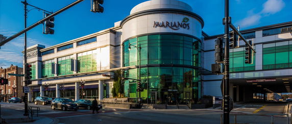 Front view of a commercial building with glass facade and rounded corner.