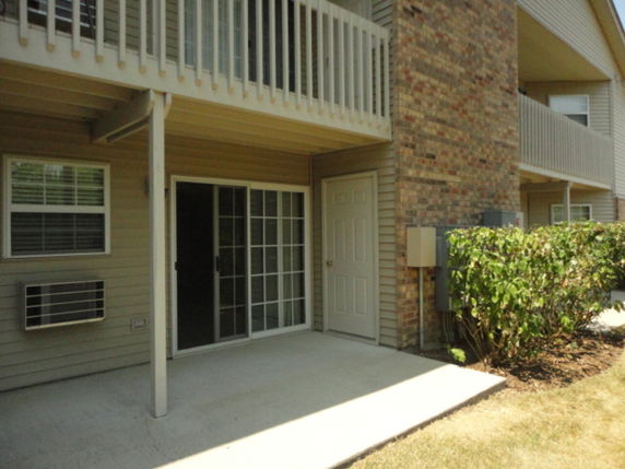 Front view of a multi-story building with balconies and sliding glass doors.