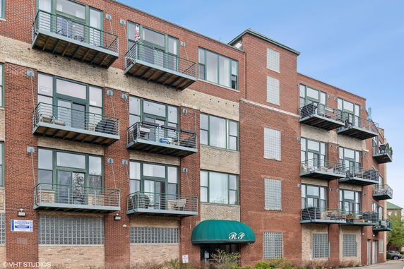 Front view of a multi-story brick building with balconies.