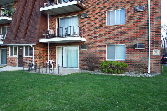 Front view of a multi-story brick apartment building with balconies.