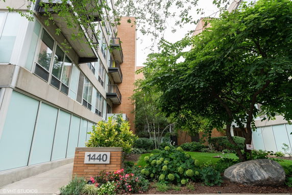 Front view of a multi-story building with balconies and large windows.