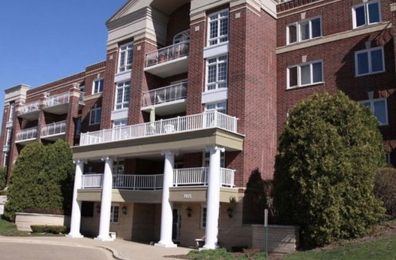 Front view of a multi-story brick building with balconies and columns.
