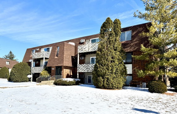Front view of a multi-story apartment building with balconies.
