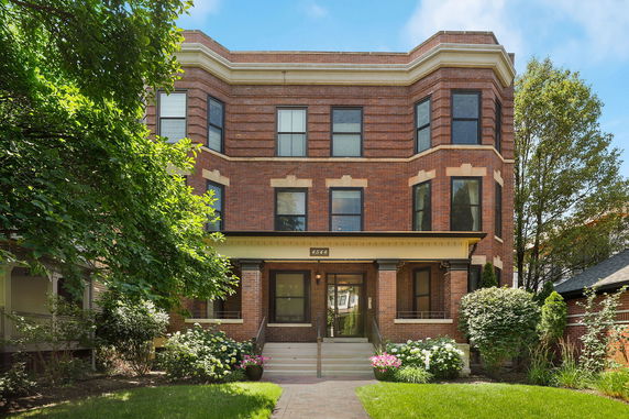 Front view of a three-story brick building with large windows.