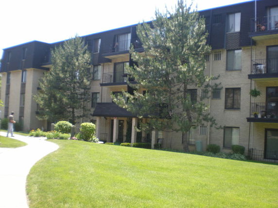 Front view of a multi-story apartment building with balconies.