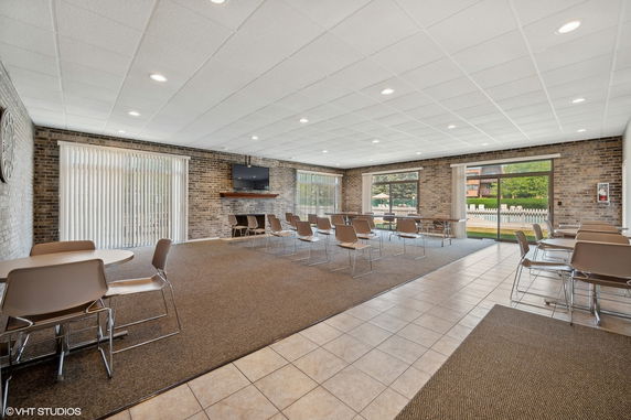 Interior view of a community room with seating and a TV