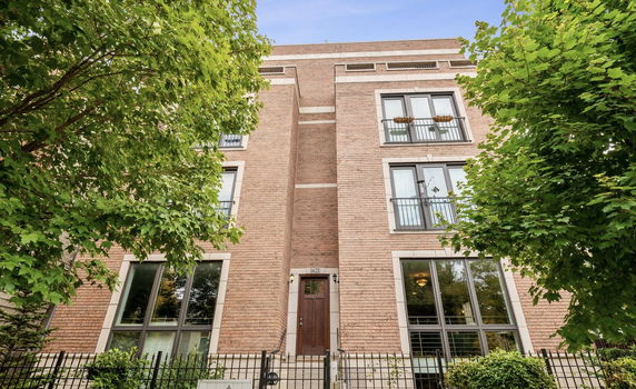 Front view of a multi-story brick building with windows and a central entrance.