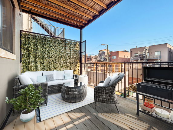 Rooftop view with a seating area and barbecue grill