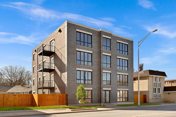 Front view of a four-story brick apartment building.