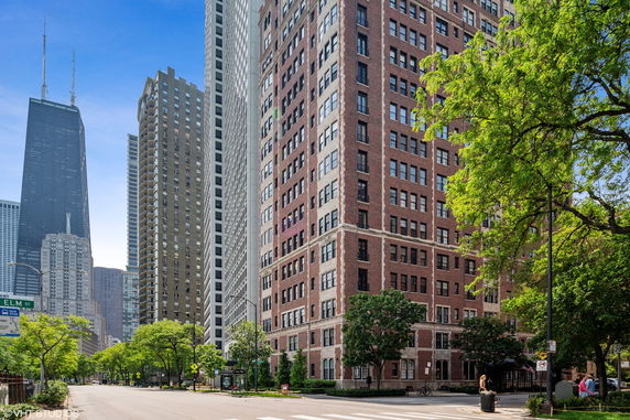 Front view of a high-rise brick building with multiple windows in an urban area.