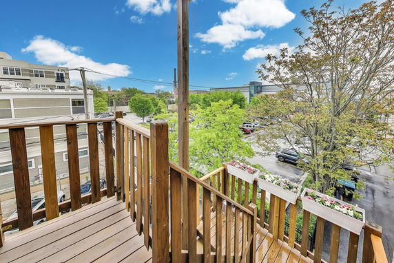 View from a wooden balcony showing surrounding area and street.