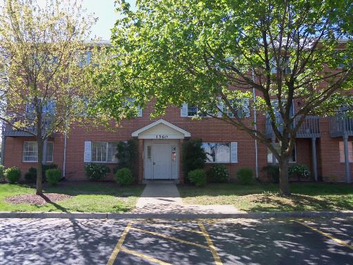 Front view of a three-story brick building with an entrance pathway.