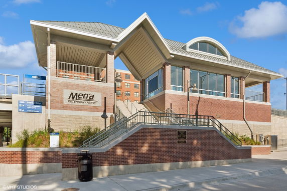 Front view of a modern train station building with brick and glass design.