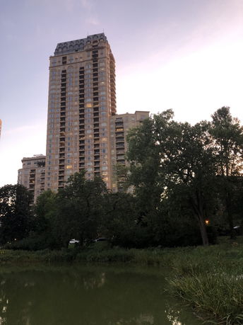 Front view of a tall apartment building with numerous windows and balconies.