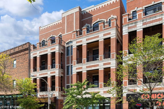 Front view of a multi-story brick building with balconies.