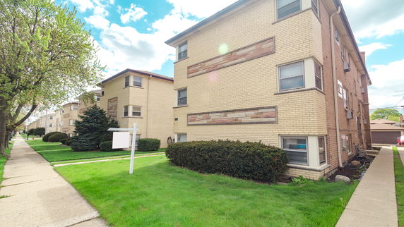 Front view of a multi-story brick apartment building.