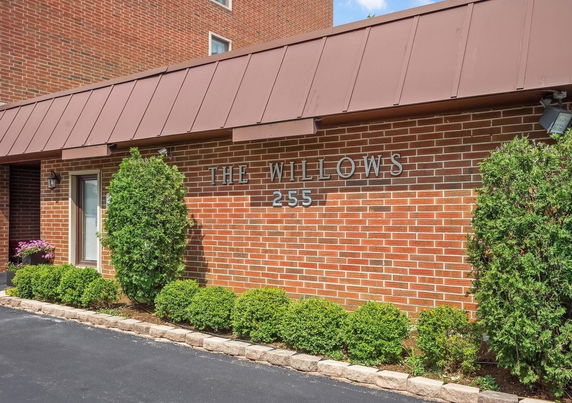 Front view of a brick building with 'The Willows 255' on the wall.