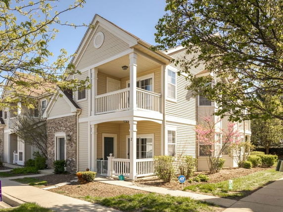 Front view of a two-story house with a porch and balcony.