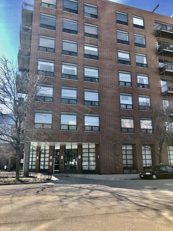 Front view of a multi-story brick building with numerous windows.