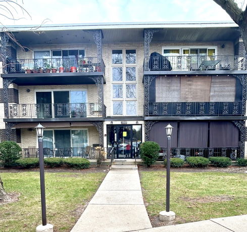 Front view of a multi-story apartment building with balconies.