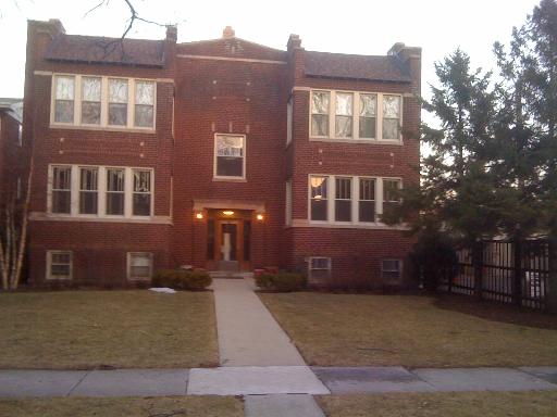 Front view of a multi-story brick building with multiple windows and entrances.