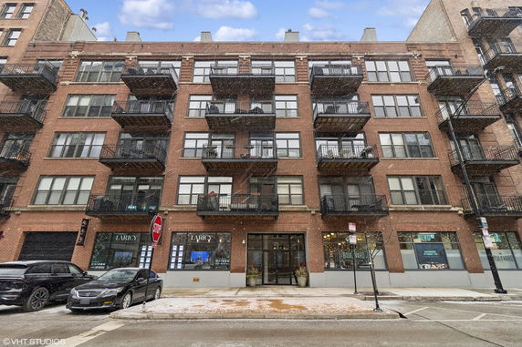 Front view of a multi-story brick building with balconies.