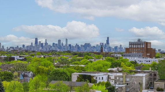 Panoramic view of a city skyline with greenery in the foreground.