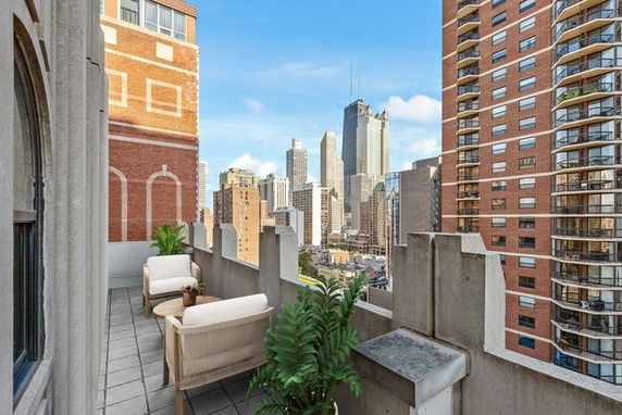 Balcony view of a city skyline with tall buildings in the background.