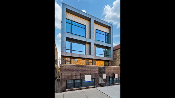 Front view of a modern multi-story building with large windows.