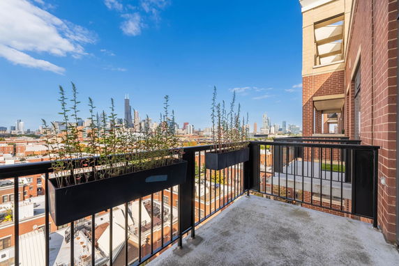 Rooftop balcony view of city skyline from a building.