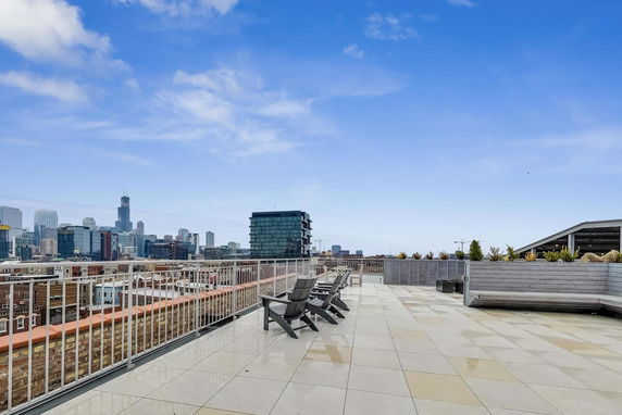 Rooftop area with seating and city skyline in the background.