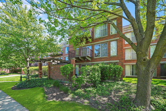 Front view of a multi-story brick apartment building with balconies.