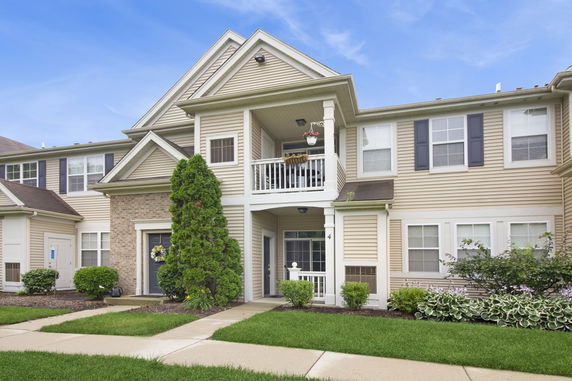 Front view of a two-story house with a small balcony and a main entrance.