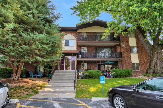 Front view of a three-story apartment building with brick façade and balconies.