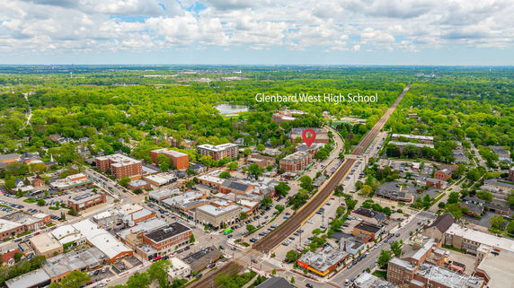 Aerial view of a town with a marked location for Glenbard West High School amidst urban and green areas.