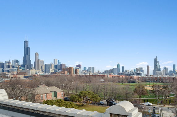 Panoramic view of a city skyline with tall buildings under a clear blue sky.