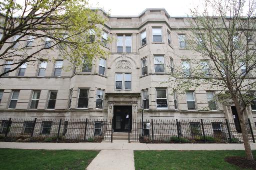 Front view of a multi-story residential building with decorative stonework.