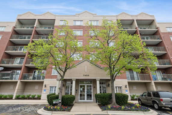 Front view of a multi-story apartment building with balconies.