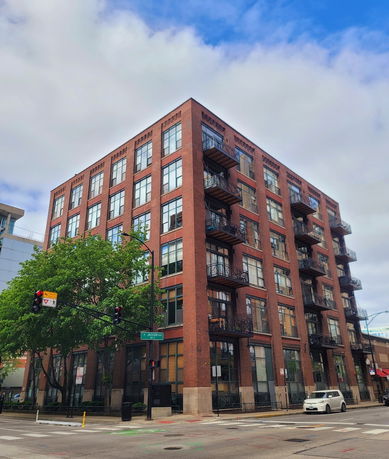 Front view of a multi-story brick building with balconies on each floor.