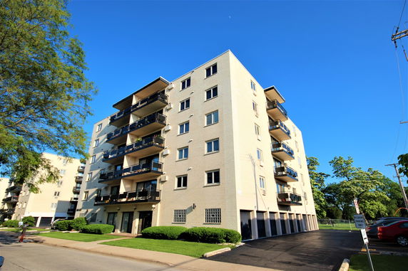 Front view of a multi-story apartment building with balconies.