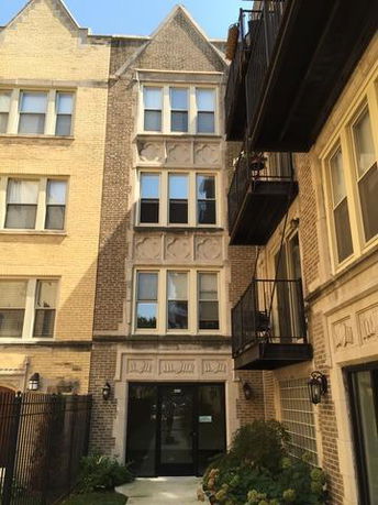 Front view of a multi-story residential building with balconies.