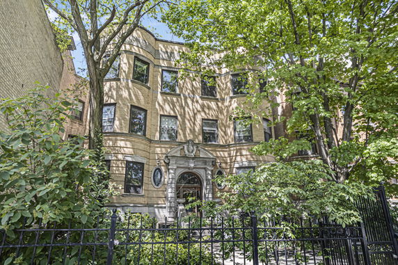 Front view of a three-story building with ornate entrance and multiple windows.
