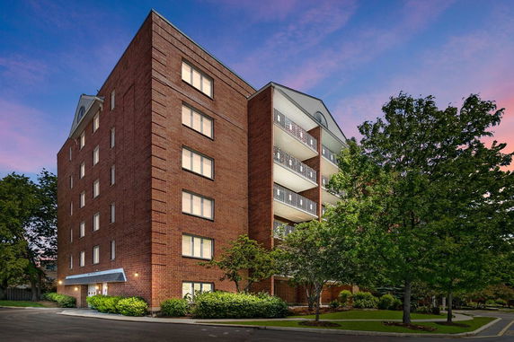 Front view of a multi-story brick building with balconies.