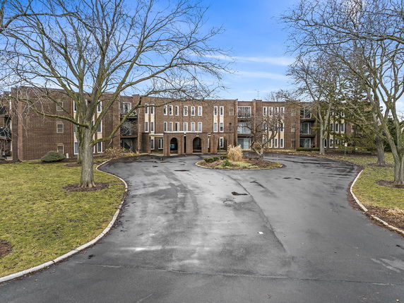 Front view of a multi-story brick building with arched entrance.