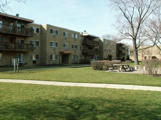 Front view of a multi-story apartment building with balconies.